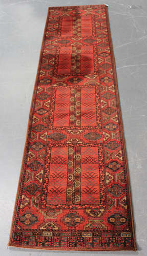 An Afghan style machine made runner, Belgium, mid-20th century, the red compartmentalized field