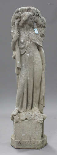 A 20th century carved stone garden figure of a maiden dressed in long robes, her raised right hand