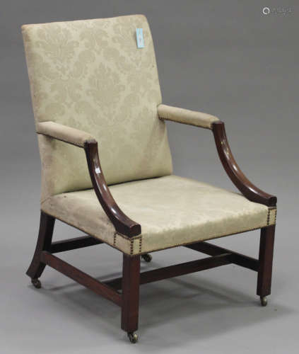 A George III mahogany Gainsborough armchair, upholstered in a cream damask, raised on block legs and