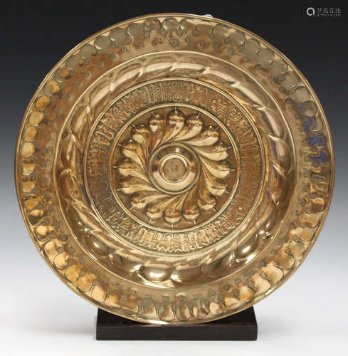 A 17th century Nuremberg brass alms dish, the central raised boss worked with a band of gadrooning