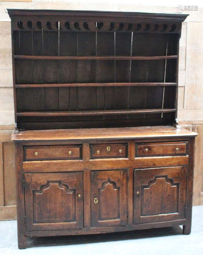 An early George III provincial oak dresser, the shelf back above drawers and cupboards, on stile