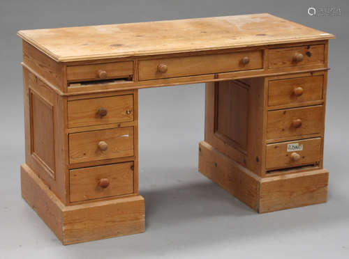 A 20th century stripped pine twin pedestal desk, fitted with nine drawers, on plinth bases, height