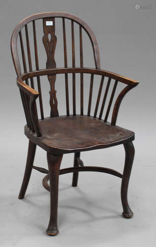 A 20th century ash and elm Windsor armchair with a pierced splat and spindle back, raised on