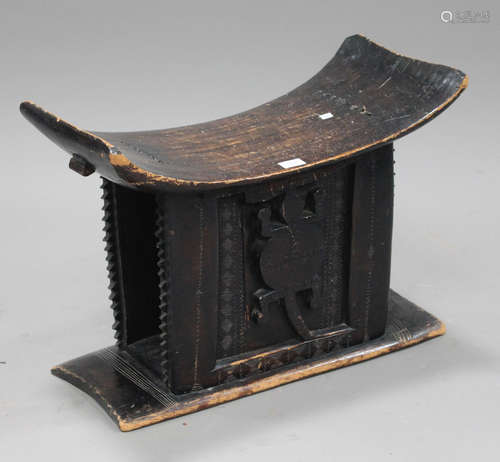 A 20th century African stained softwood Ashanti stool, the sides carved with a reptile, width 62cm.