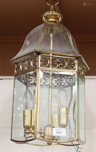 A modern brass framed hall lantern with inset bevelled glass panels, height 52cm.Buyer’s Premium