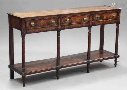 A George III provincial oak dresser base, fitted with three frieze drawers, raised on turned