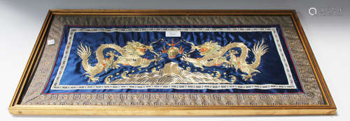 A Chinese metal and silk thread embroidered panel depicting opposing dragons flanking the flaming