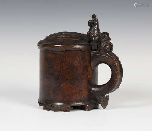 An 18th century Scandinavian burr wood peg tankard, the lid carved in relief with a stylized lion,