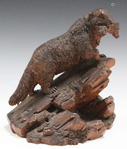 An early 20th century Swiss Black Forest carved softwood model of an animal, standing on a rocky