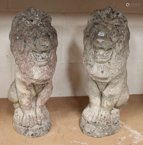 A pair of 20th century cast composition stone garden models of seated lions, height 46cm.