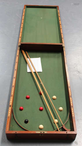 A late Victorian mahogany cased bagatelle board, the green baize interior with mace, cue and a set