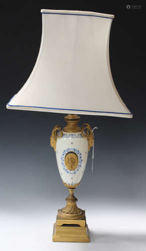 A 20th century French porcelain and gilt metal mounted table lamp, the white silk shade above an