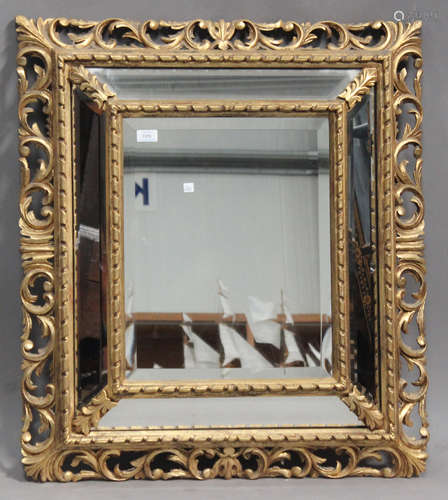 A late 19th century Florentine giltwood sectional wall mirror with bevelled edges and a foliate