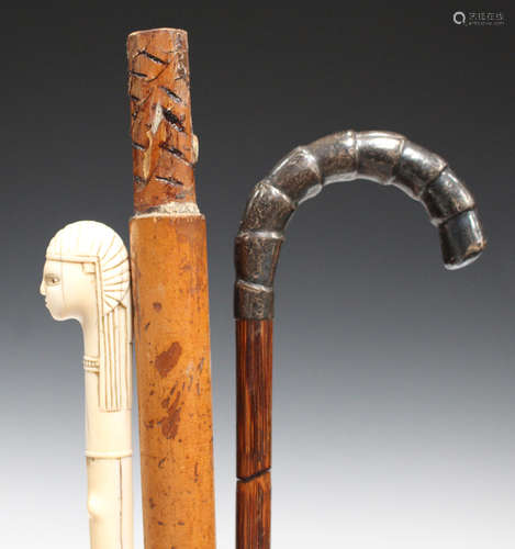 An early 20th century ivory handled parasol, carved in the form of a pharaoh's head, together with