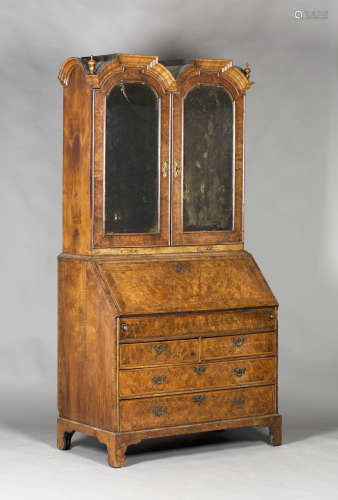 A Queen Anne and later walnut bureau bookcase, the double dome pediment fitted with two turned