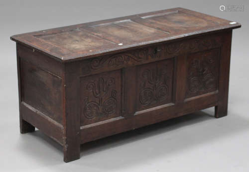 A late 17th/early 18th century oak coffer, the hinged top above a triple panel front with later