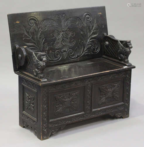 A late Victorian carved oak box seat monk's bench, on bracket feet, height 66cm, width 107cm,