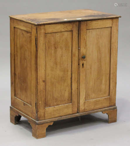 A Victorian stripped pine cupboard, enclosed by two panelled doors, on bracket feet, height 93cm,