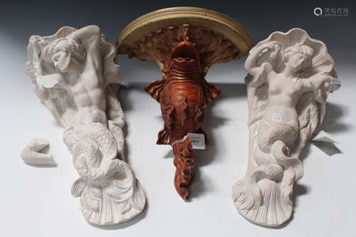 A modern moulded composition wall bracket with a stylized carp support, height 41cm, together with a