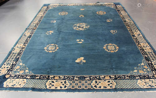 A Chinese carpet, early 20th century, the blue field sparsely decorated with flower sprigs and