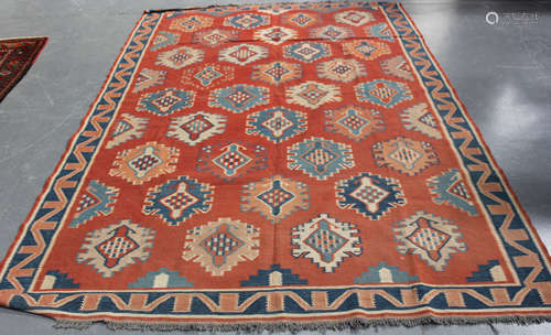 An Afghan kelhim carpet, mid-20th century, the terracotta field with overall offset palmettes,