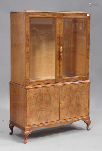 An early/mid-20th century walnut display cabinet, the maple-lined interior fitted with glass shelves