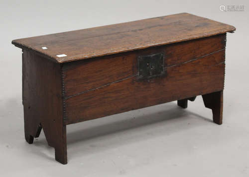 A late 17th century oak six plank coffer, the hinged lid on shaped side supports, height 48cm, width