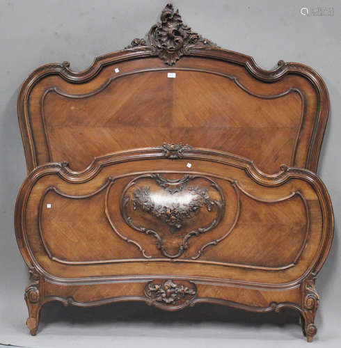 A late 19th century French walnut double bed, the shaped headboard carved with a foliate scroll