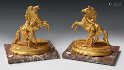 After Guillaume Coustou - a pair of gilt painted cast metal figures of Marly horses and