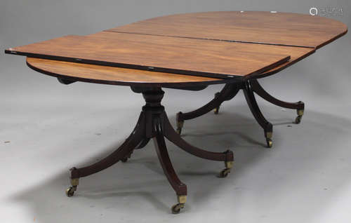 A George III and later mahogany twin pedestal dining table fitted with a single extra leaf, raised