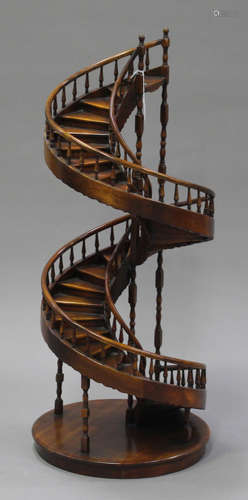 A late 20th century stained hardwood novelty model of a spiral staircase with spindle supports and a