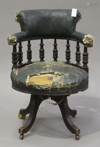 A late Victorian stained walnut revolving tub back desk chair with spindle supports and downswept