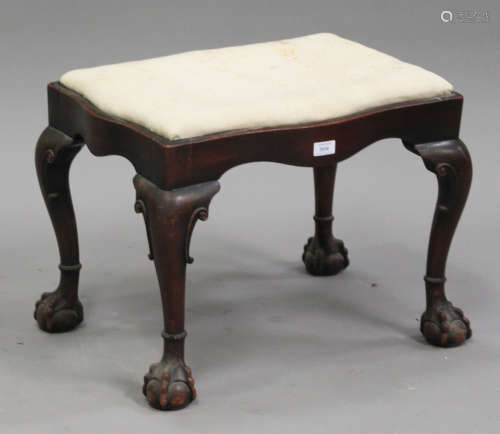 A late 19th century George I style stained walnut stool, the serpentine shaped seat raised on carved