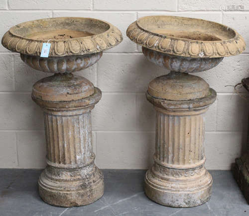 A pair of late 19th/early 20th century moulded earthenware campana garden urns of squat form,