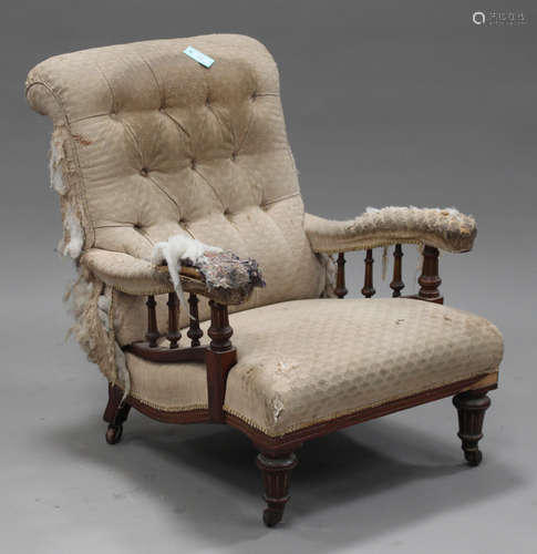 An Edwardian walnut salon armchair, upholstered in buttoned cream fabric, raised on turned and