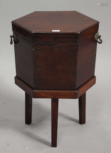 A George III mahogany hexagonal wine cooler, the hinged lid and slightly tapered body raised on