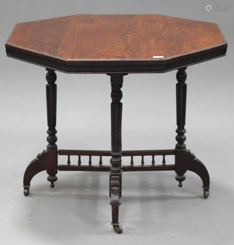 A Victorian walnut octagonal centre table, raised on turned and fluted supports and downswept