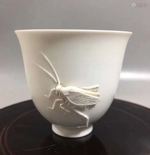 A WHITE GLAZE CRICKET SHAPED CUP