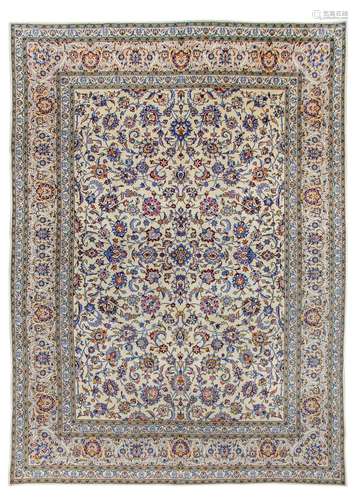 A KASHAN CARPET, CERNTRAL PERSIA approx: 13ft.10in. x 9ft.10in.(422cm. x 299cm.) The ivory field with overall design of multi-coloured palmettes, floral sprays and serrated leaves together with meandering floral vine. In light-beige border of bold polychrome palmettes, arabesques and delicate floral vine, between similar triple stripes. Outer plain stripe. This carpet has full pile, soft wool quality, very nicely drawn design, lovely pastel appearance. In general this carpet is in vey good condition throughout. Ends with short fringes, secured. Selvages rebound, well done. Great furnishing piece. Attractive. Woven mid 20th. century.