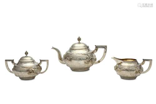 A CHINESE THREE PIECE EXPORT SILVER TEA SET. Circa 1920. Decorated in repoussé with a coiled dragon