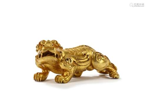 A CHINESE GILT BRONZE MYTHICAL BEAST WEIGHT. Standing on all fours, the head turned slightly to the