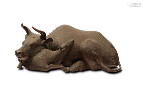A CHINESE LARGE BRONZE ‘BUFFALO GROUP’ SCULPTURE. Naturalistically modelled as a seated cow the