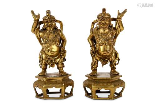 A PAIR OF CHINESE BRONZE ‘FOREIGNERS’ CANDLESTICKS. The bearded figures standing on hexagonal