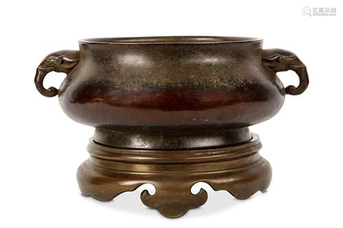 A CHINESE BRONZE TWIN HANDLED CENSER WITH STAND. Of blombé form with elephant head handles,