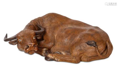 A CHINESE BROWN-GLAZED SEATED BUFFALO. 37cm long. 醬釉水牛臥像