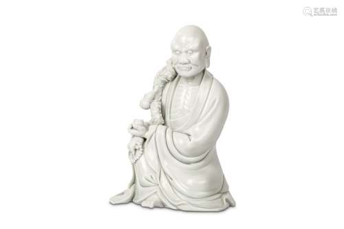A CHINESE BLANC DE CHINE FIGURE OF LI TIEGUAI Qing Dynasty. Seated in flowing robes with the left