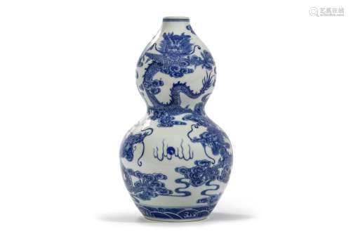 A CHINESE BLUE AND WHITE ‘DRAGON’ VASE. Of double gourd form, painted to the exterior with dragons