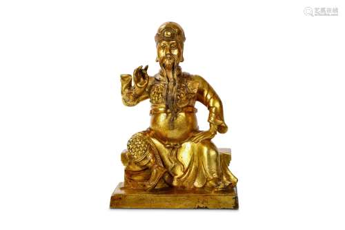 A CHINESE GILT BRONZE FIGURE OF GUANYU. Qing Dynasty. Seated in flowing robes concealing his