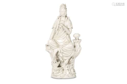 A CHINESE BLANC DE CHINE FIGURE OF GUANYIN. 20th Century. Seated on a rocky base, the left hand