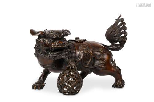 A BRONZE BUDDHIST LION DOG CENSER, 19th Century. Standing with one of his paws resting on a ball,